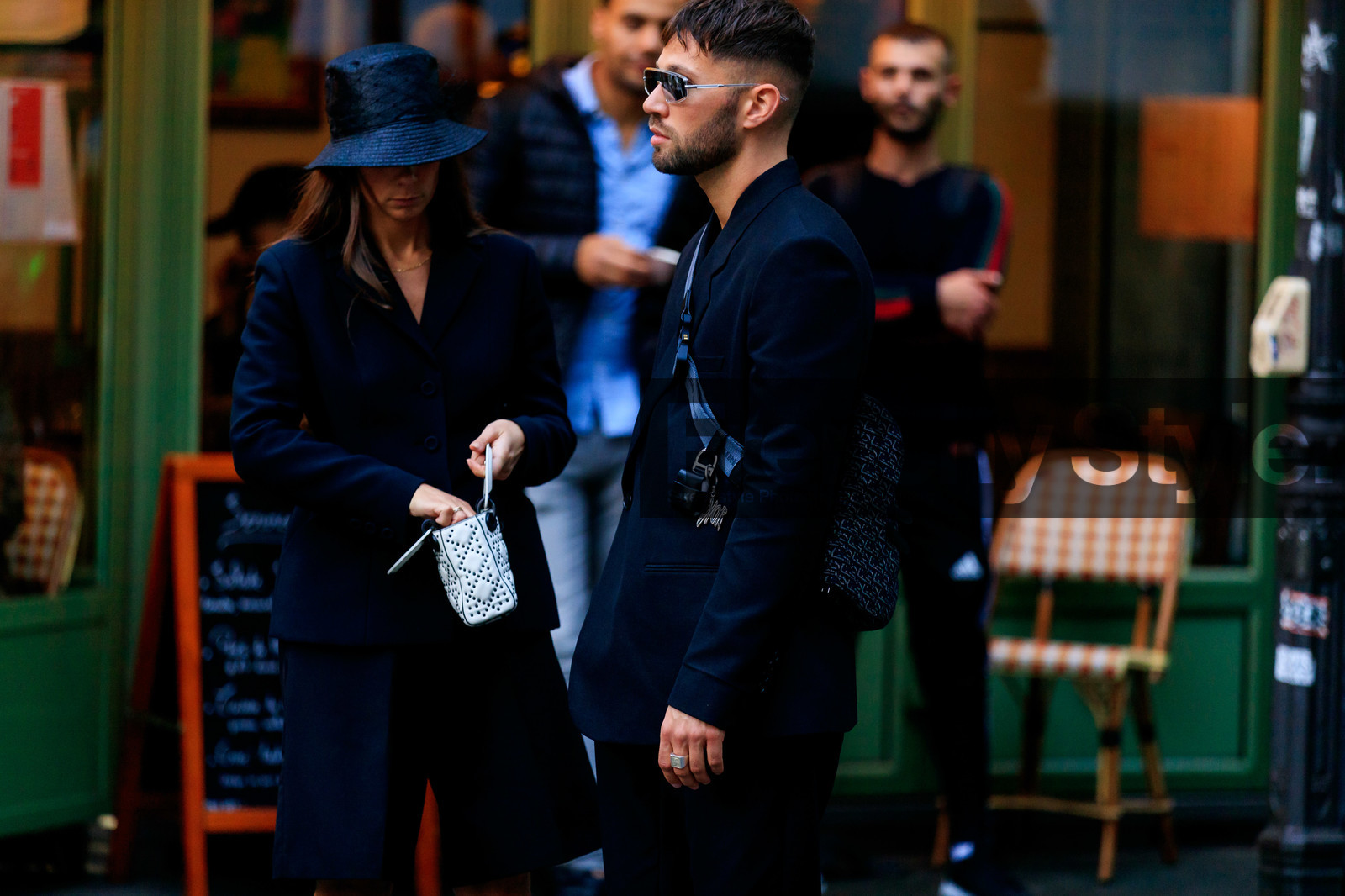 alice & j.s, alice barbier, JS roques, white sunglasses, futurist shape sunglasses, black jacket, black pants, black bermuda shorts, dior bag, dior jacket, dior pants, dior shorts, dior total look, monogrammed bag, crossbody bag, blue bag, dior saddle bag, fashion week, frenchystyle, FW, jonathan paciullo, street style, SPRING SUMMER 2020, SS 20, PFW, PARIS, horizontal, atmosphere details, detail