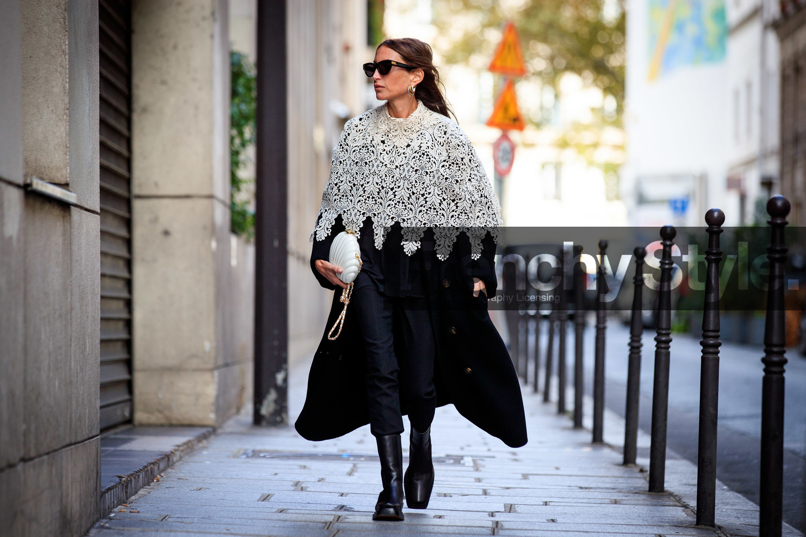 chloe loulou de saison, white cape, lace cape, white leather bag, white bag, shell bag, shell frame bag, bottega veneta sunglasses, chanel bag, black sunglasses, black coat, black pants, black leather boots, flat boots, hoop earrings, golden earrings, silvered earrings, multi earrings, black and white look, PARIS, PFW, fashion week, frenchystyle, FW, jonathan paciullo, street style, SPRING SUMMER 2021, SS 21, horizontal, atmosphere details, full length