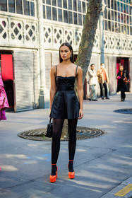 valentino, valetino earrings, logo earrings, mini dress, black dress, leather dress, black stockings, valentino bag, black handbag, studded handbag, orange heels, platform heels, sarah lysander, street style, jonathan paciullo, FW, frenchystyle, fashion week, AUTUMN WINTER 2022-2023, FALL WINTER 2022_2023, FW 22-23, PARIS, PFW, full length, vertical