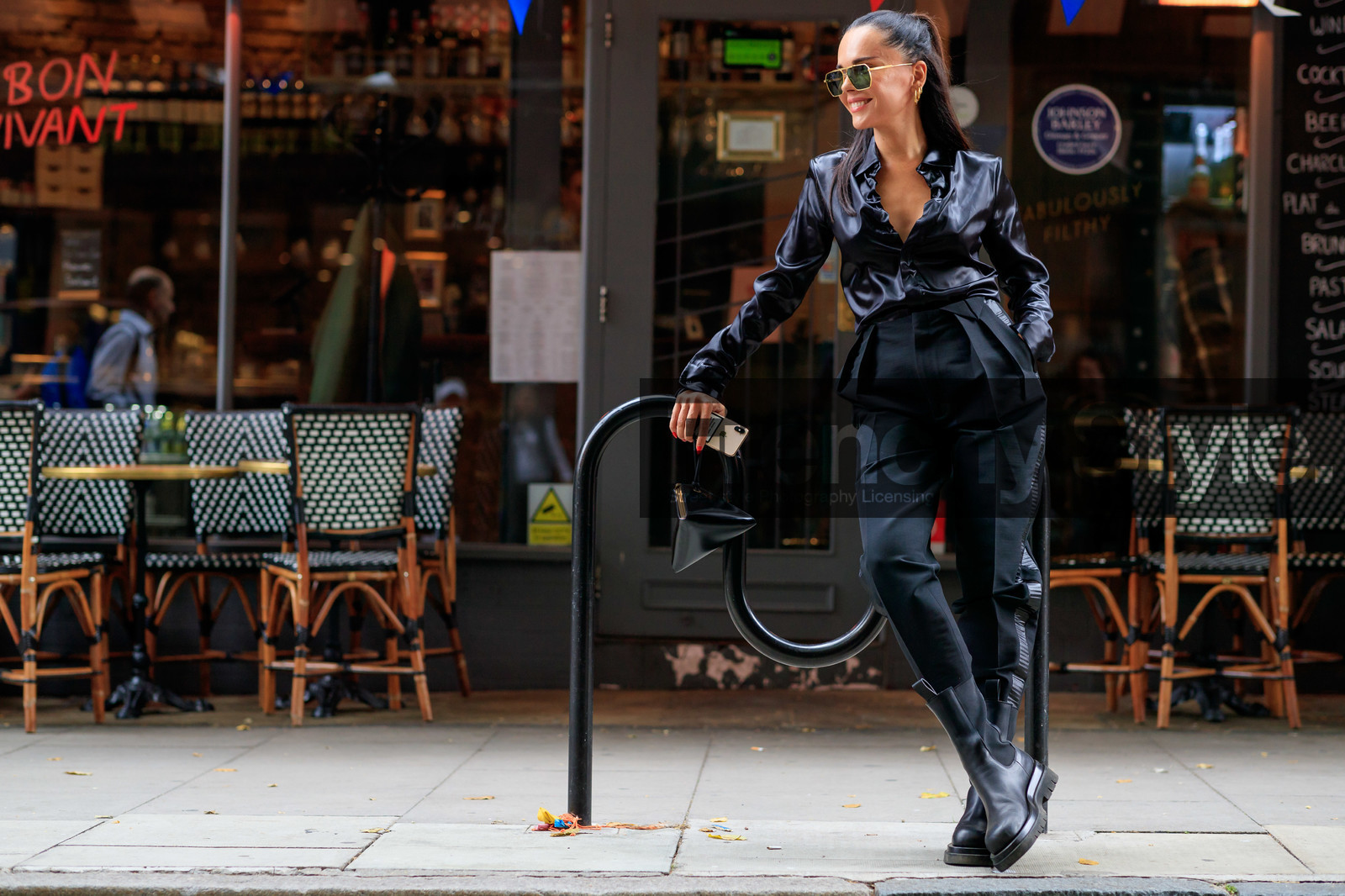 evangelie smyrniotaki, satin shirt, metalic frame sunglasses, hoop earrings, golden earrings, geometric bag, chelsea boots, carrot pants, bottega veneta bag, black total look, black shirt, black pants, black leather clutch, black leather boots, aviator sunglasses, fashion week, frenchystyle, FW, jonathan paciullo, street style, atmosphere details, horizontal, full length