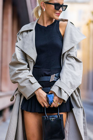 bag, beige trenchcoat, black bag, black skirt, Caroline Daur, marcel, prada bag, prada skirt, skirt, small bag, sunglasses, trenchcoat, pleatde, pleated skirt, mini skirt, fashion week, frenchystyle, FW, jonathan paciullo, street style, MFW, MILAN, SPRING SUMMER 2022, SS 22, vertical, atmosphere details, detail
