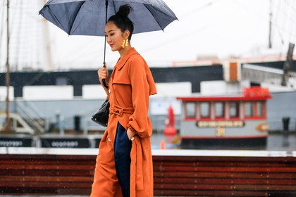 black bag, bun, earrings, leather bag, navy pants, orange coat, trench coat, trousers, umbrella, street style, jonathan paciullo, FW, frenchystyle, fashion week, NYFW, NEW YORK, AUTUMN WINTER 2018-2019, AW 18-19, FALL WINTER 2018-2019, FW 18-19, atmosphere details, horizontal, detail