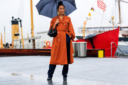 black bag, black shoes, bun, earrings, leather bag, leather shoes, navy pants, orange coat, trench coat, trousers, umbrella, street style, jonathan paciullo, FW, frenchystyle, fashion week, NYFW, NEW YORK, AUTUMN WINTER 2018-2019, AW 18-19, FALL WINTER 2018-2019, FW 18-19, atmosphere details, horizontal, full length