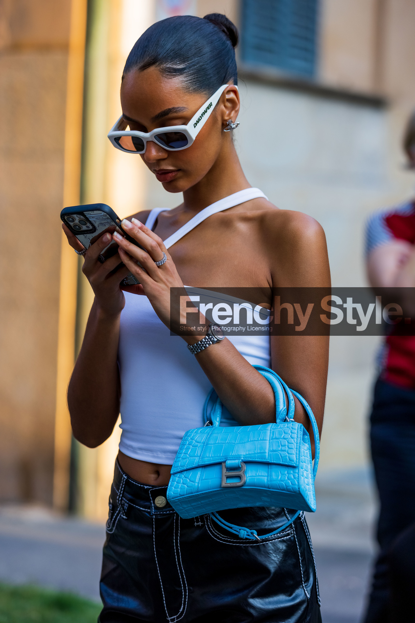 asymetrical top, bag, balenciaga bag, blue bag, bun, croc bag, detail, hourglass bag, Jamilla Stand, leather bag, smartphone, sunglasses, watch, white sunglasses, white top, fashion week, frenchystyle, FW, jonathan paciullo, street style, MFW, MILAN, SPRING SUMMER 2022, SS 22, vertical, atmosphere details