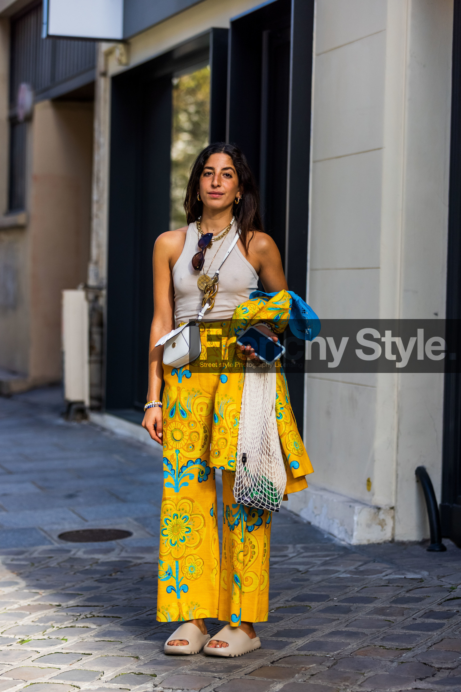 beige mules, beige sandals, beige tank top, color, crossbody bag, fishnet bag, flare pants, floral pants, floral print, flower print, jw anderson bag, mules, pants, print, printed pants, Selma Kaci, tank top, white bag, yellow pants, street style, jonathan paciullo, FW, frenchystyle, fashion week, PFW, PARIS, SPRING SUMMER 2022, SS 22, vertical, full length