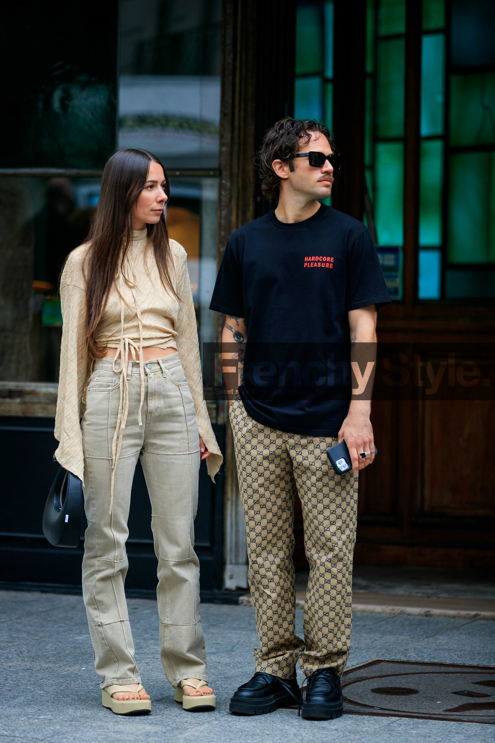 nude blouse, light beige blouse, beige blouse, cropped blouse, high collar blouse, high collar, high waist jeans, beige jeans, denim, striped blouse, knot details, knoted blouse, black leather bag, round shape bag, hand bag, coperni bag, patchwork jeans, flare jeans, platform sandals, platform slippers, beige leather sandals, beige leather slippers, flip flop shoes, golden earrings, hoop earrings, multi earrings, alice & j.s, alice barbier, tatoo, tatoo detail, black t-shirt, letter printed t-shirt, red t-shirt, black sunglasses, square shape glasses, monogrammed pants, logo printed pants, gucci pants, alice barbier, JS roques, alice & j.s, fashion week, frenchystyle, FW, jonathan paciullo, street style, PFW, PARIS, SPRING SUMMER 2022, SS 22, vertical, full length