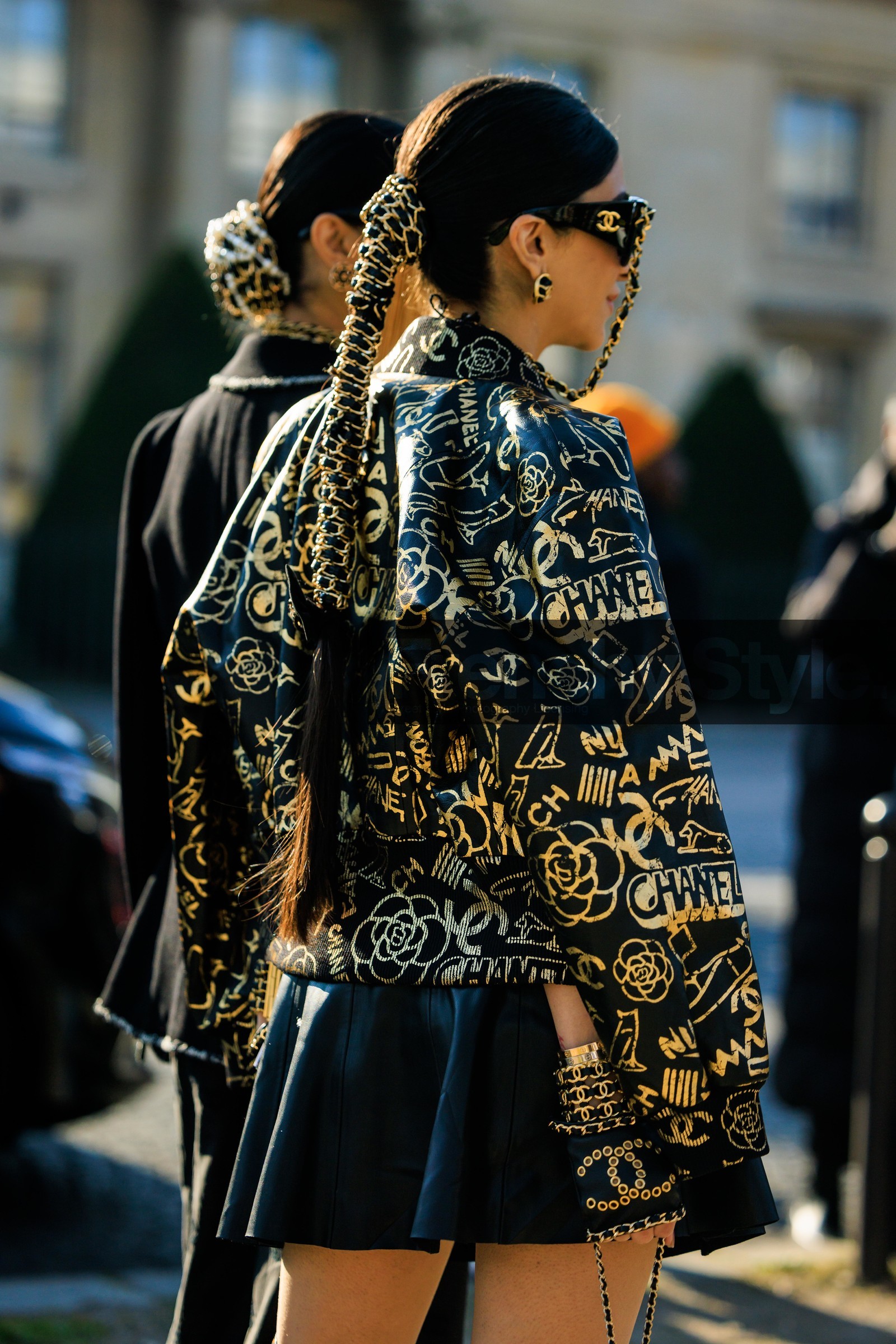 chanel sunglasses, black sunglasses, chanel studs, logo earrings, braided hair tail, logo jacket, chanel jacket, bomber jacket, golden jacket, mini skirt, back details, chanel bracelet, chanel gloves, black gloves, street style, jonathan paciullo, FW, frenchystyle, fashion week, AUTUMN WINTER 2022-2023, FALL WINTER 2022_2023, FW 22-23, PFW, PARIS, vertical, detail