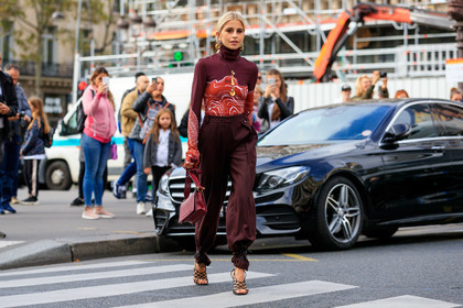 caro daur, stella mccartney bag, stella mccartney look, stella mccartney look, stella mccartney top, stella mccartney pants, burgundy pants, burgundy leather bag, burgundy top, red top, tight top, high collar top, turtleneck top, tailored pants, loose pants, golden earrings, golden necklace, long necklace, dangling earrings, hoop earrings, round earrings, round shape earrings, diamond earrings, big earrings, big necklace, charms necklace, black leather sandals, multi straps sandals, high heels sandals, long sleeves top, printed top, PARIS, PFW, SPRING SUMMER 2020, SS 20, fashion week, frenchystyle, FW, jonathan paciullo, street style, horizontal, atmosphere details, full length