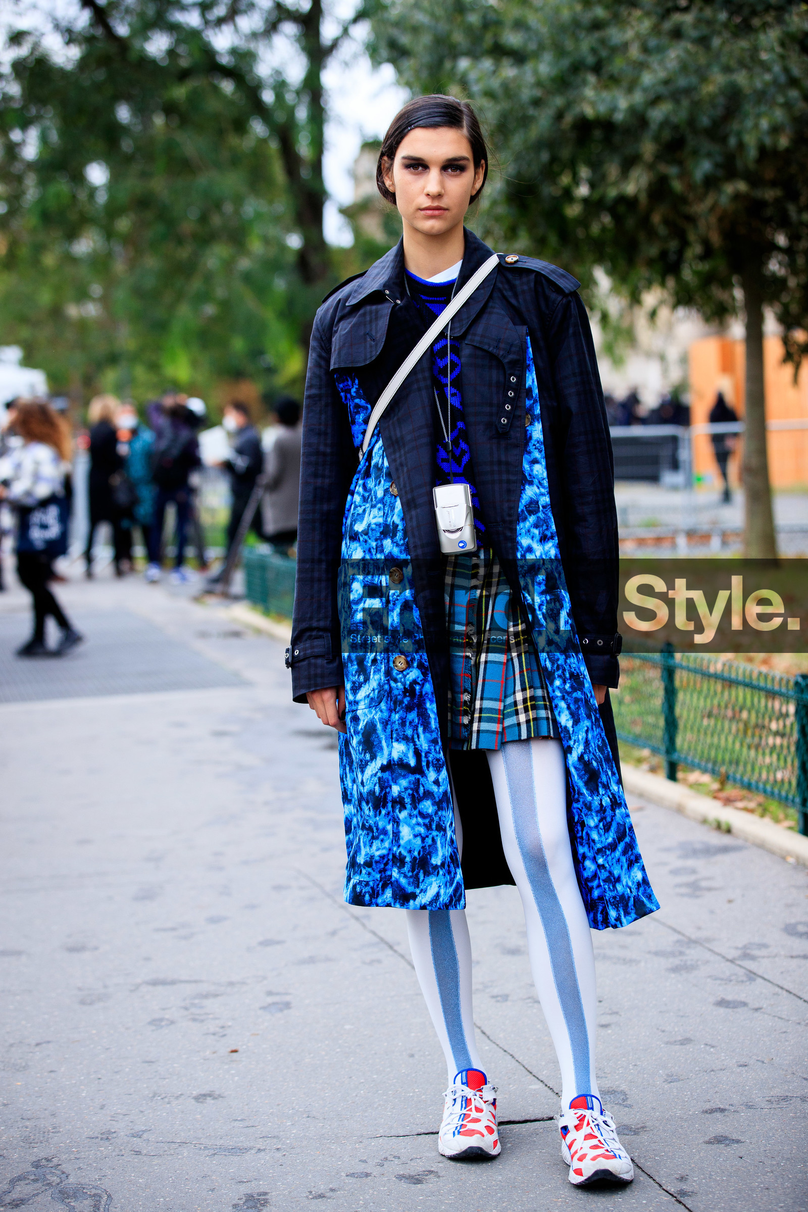 make up, make up details, hair details, navy blue trench coat, blue trench coat, blue skirt, blue pullover, blue tights, striped tights, lurex tights, tie and dye trenchcoat, checked skirt, plaid skirt, pleated skirt, mini skirt, kilt skirt, checked trench coat, red sneakers, white sneakers, jacquard pullover, geometrical printed pullover, black eyeliner, black eyeshadows, PARIS, PFW, fashion week, frenchystyle, FW, jonathan paciullo, street style, SPRING SUMMER 2021, SS 21, vertical, full length, model