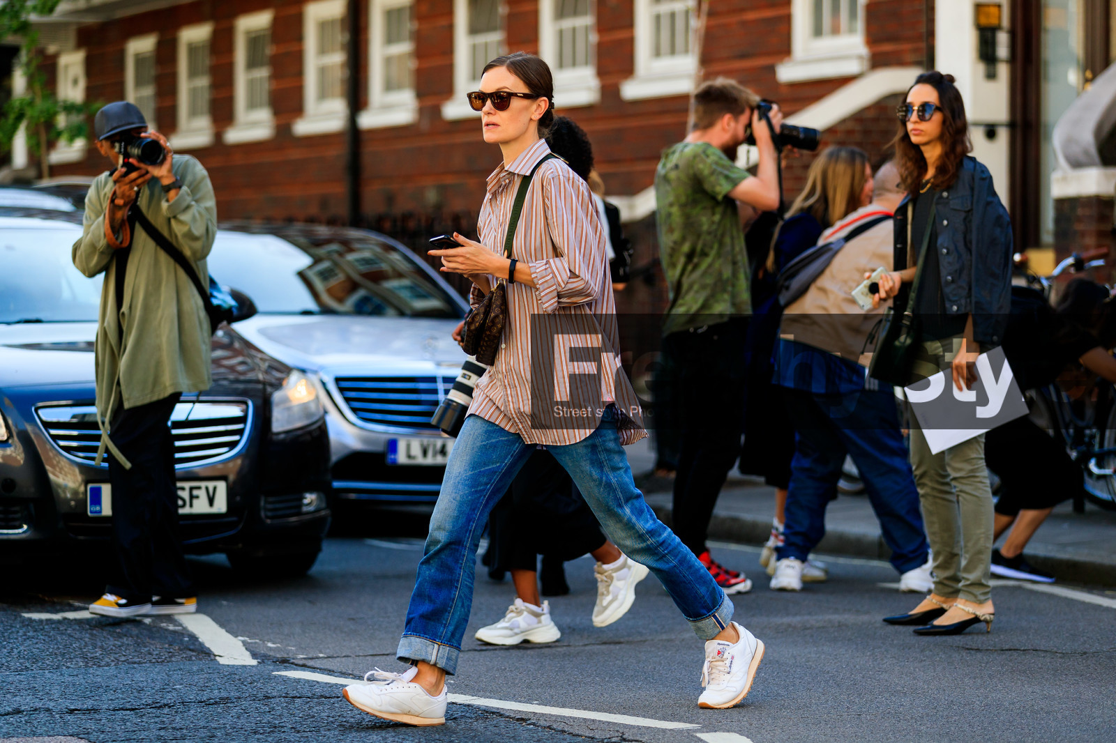 jo ellison, brown scale sunglasses, striped shirt, orange shirt, blue jeans, used jeans, denim, reebok sneakers, louis vuitton bag, logo shoulder strap, crossbody bag, fashion week, frenchystyle, FW, jonathan paciullo, street style, atmosphere details, horizontal, full length
