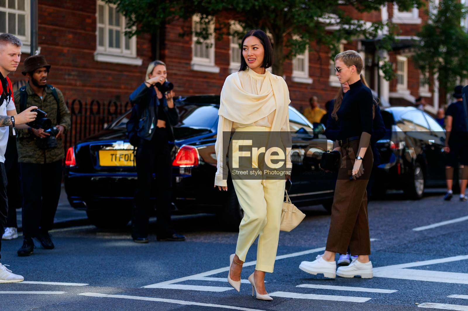 Tiffany Hsu, yellow total look, light yellow pants, light yellow blouse, high collar blouse, carrot pants, long sleeve blouse, scarf blouse, high heels shoes, light beige shoes, ankle bracelet, white leather bag, animal skin bag, mini bag, hand bag, fashion week, frenchystyle, FW, jonathan paciullo, street style, atmosphere details, horizontal, full length