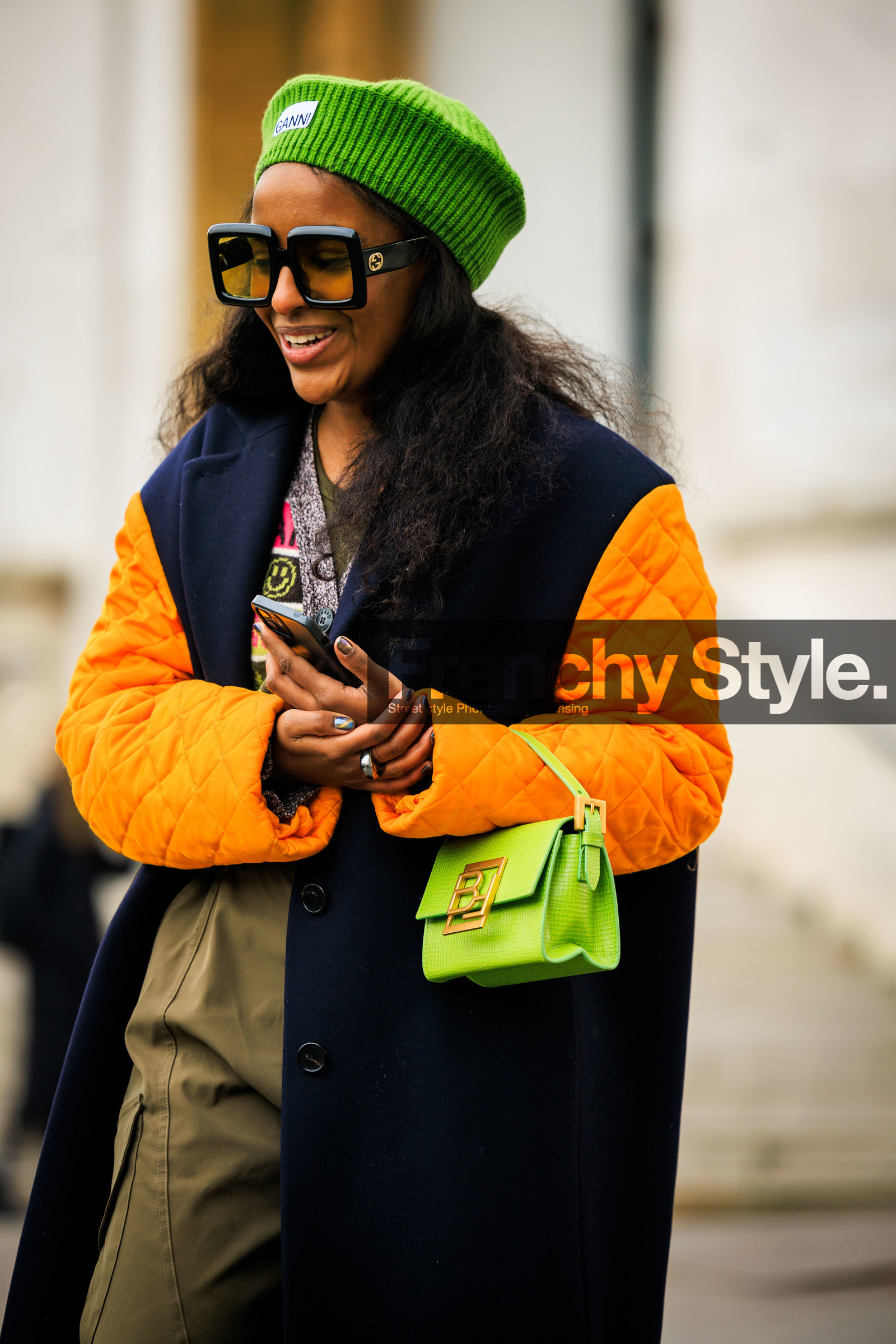 ganni beanie, green beanie, orange sleeves, black winter coat, kaki pants, baggy trousers, black belt, green handbag, black sunglasses, ganni cardigan, ganni cardigan, multicolor cardigan, green top, fashion week, frenchystyle, FW, jonathan paciullo, street style, AUTUMN WINTER 2022-2023, FALL WINTER 2022_2023, FW 22-23, PFW, PARIS, vertical, detail, dual toned jakcet