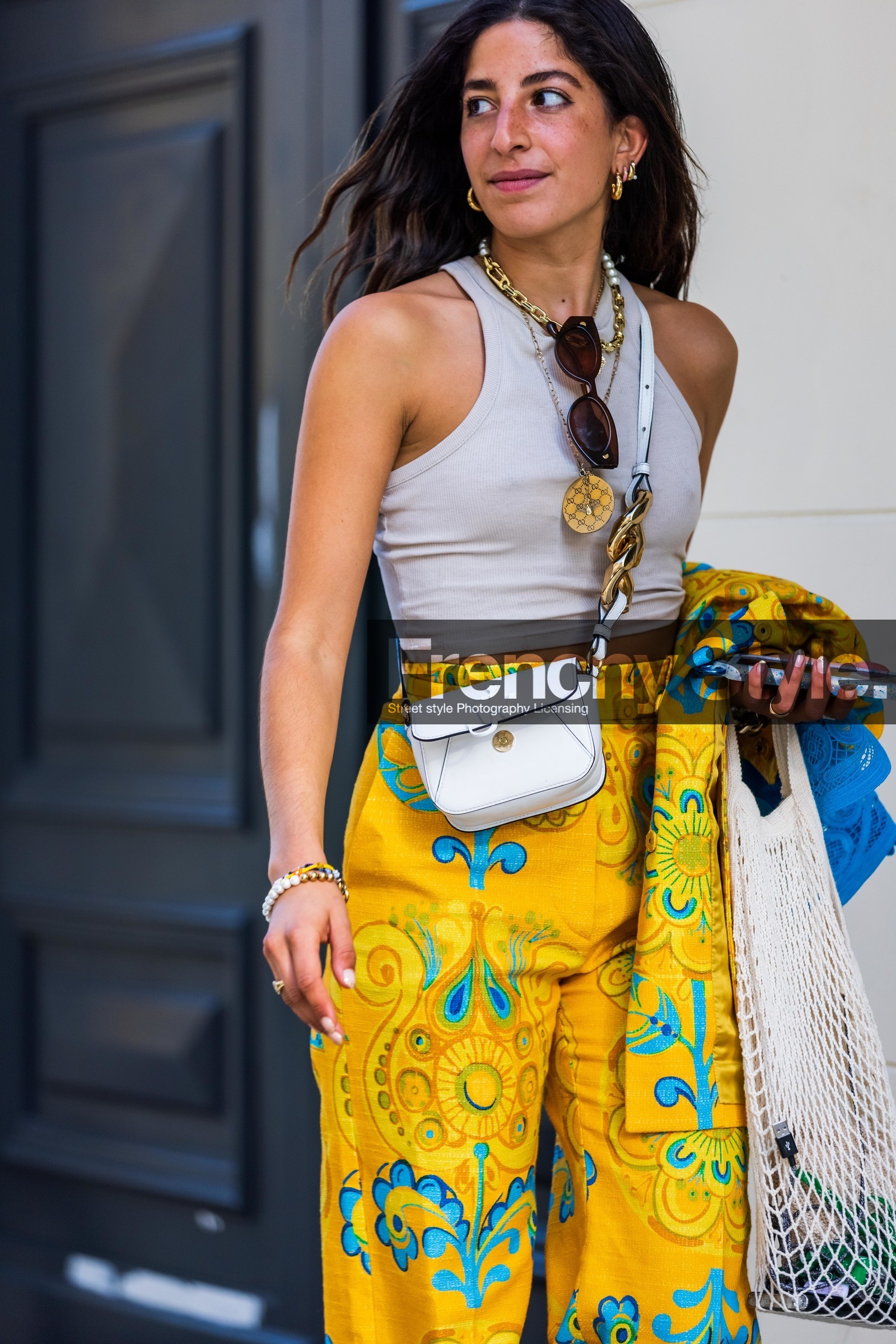 beige mules, beige sandals, beige tank top, color, crossbody bag, fishnet bag, flare pants, floral pants, floral print, flower print, jw anderson bag, mules, pants, print, printed pants, Selma Kaci, tank top, white bag, yellow pants, street style, jonathan paciullo, FW, frenchystyle, fashion week, PFW, PARIS, SPRING SUMMER 2022, SS 22, vertical, atmosphere details