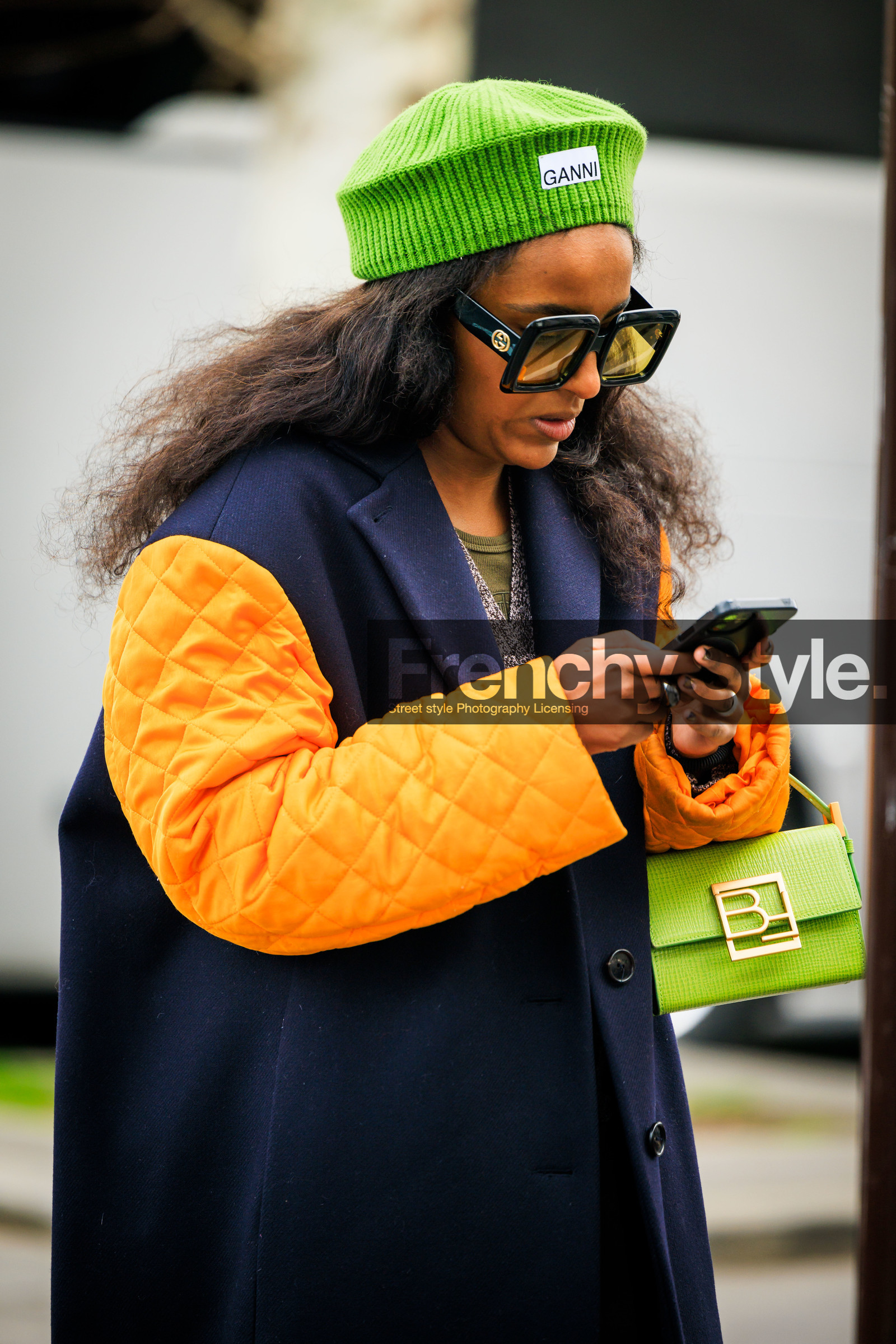 ganni beanie, green beanie, orange sleeves, black winter coat, kaki pants, baggy trousers, black belt, green handbag, black sunglasses, ganni cardigan, ganni cardigan, multicolor cardigan, green top, fashion week, frenchystyle, FW, jonathan paciullo, street style, AUTUMN WINTER 2022-2023, FALL WINTER 2022_2023, FW 22-23, PFW, PARIS, vertical, detail, dual toned jakcet